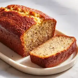 A close-up shot of the key ingredients for moist banana bread, including overripe bananas, flour, and sugar, arranged neatly.