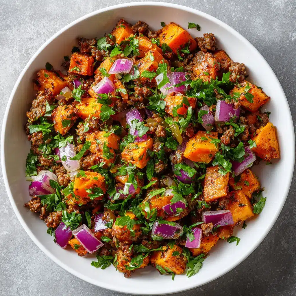 A spoonful of the one-pan beef and sweet potato hash being lifted from the skillet, ready to be served. A perfect example of an easy weeknight dinner.