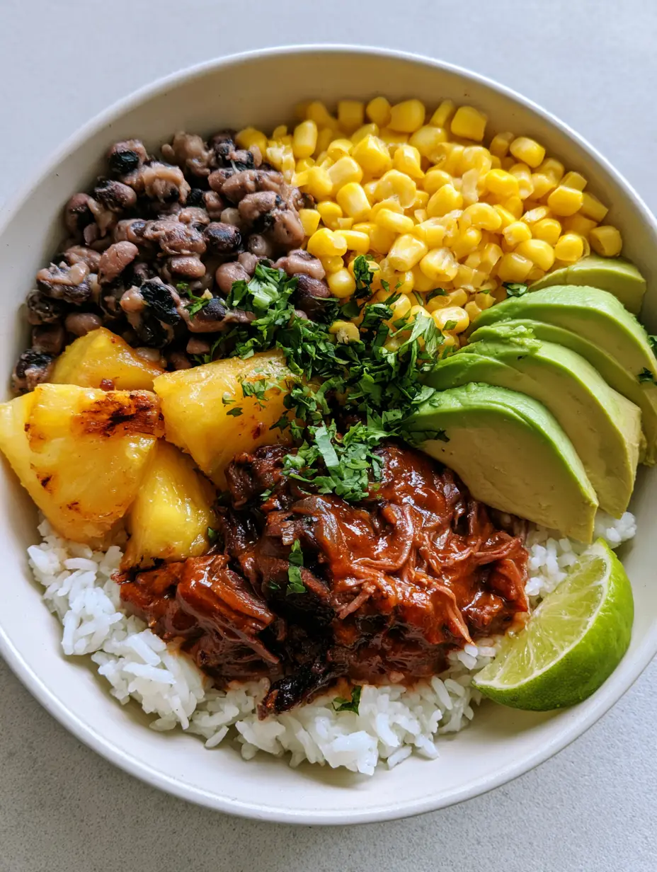 Chipotle Pineapple Pot Roast: The Ultimate Sweet and Smoky Slow Cooker Meal 4 Top-down view of a white ceramic bowl featuring tender shredded beef in a thick reddish-brown sauce and golden charred pineapple chunks. (Chipotle Pineapple Pot Roast)